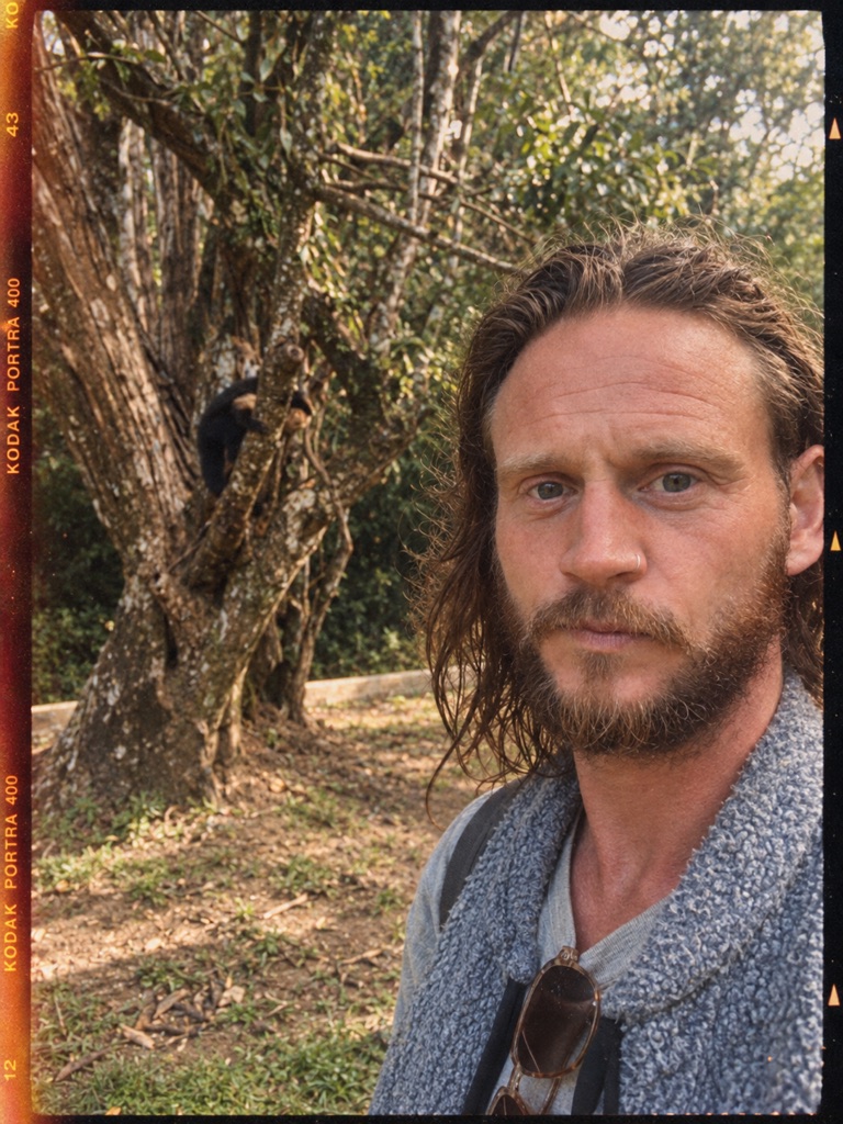 Simon outdoors among trees.
